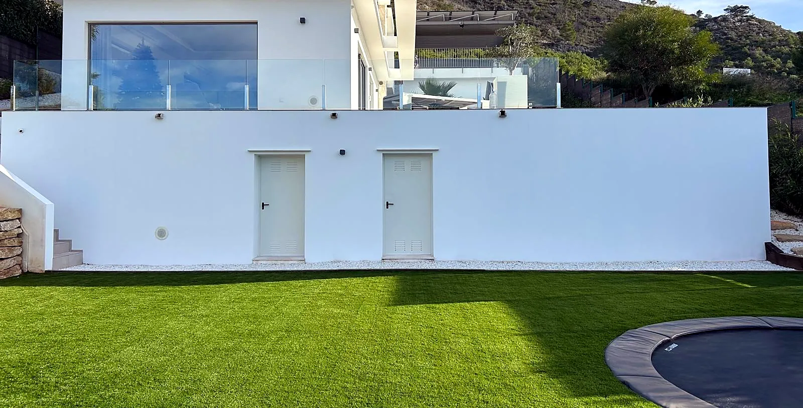 Frisch gestrichene weiße Villenfassade mit Rasen